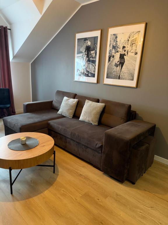a living room with a brown couch and a table at Apartament Umami in Pniewy