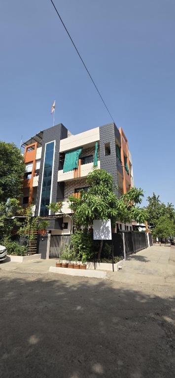 a building with a tree in front of it at 2 BHK All AC Rooms Solapur Home Stay By Stay Nestura in Solapur