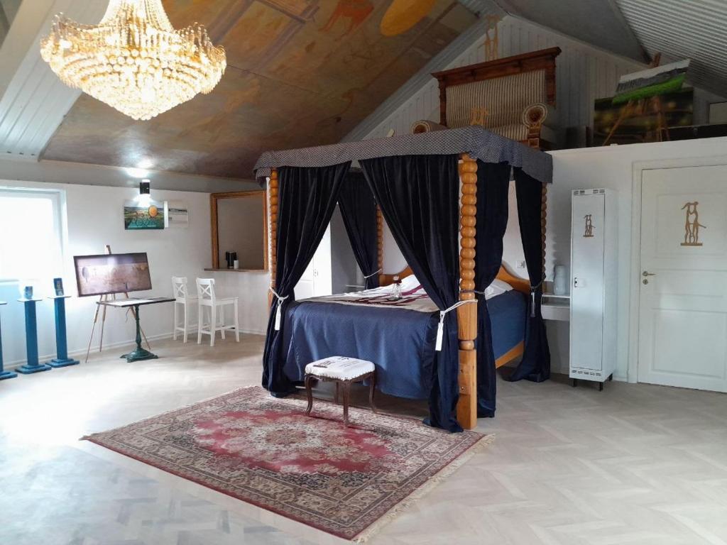 a bedroom with a canopy bed with a chair and a rug at Borgahallen The Wedding Room in Rimbo