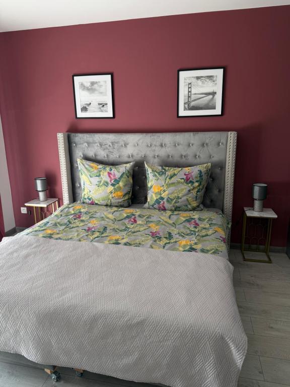 a bedroom with a large bed with purple walls at Apartament Helsinki in Pniewy