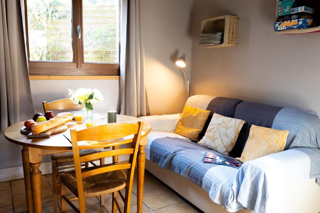 a living room with a table and a couch at Les Colombes in Saint-Tricat