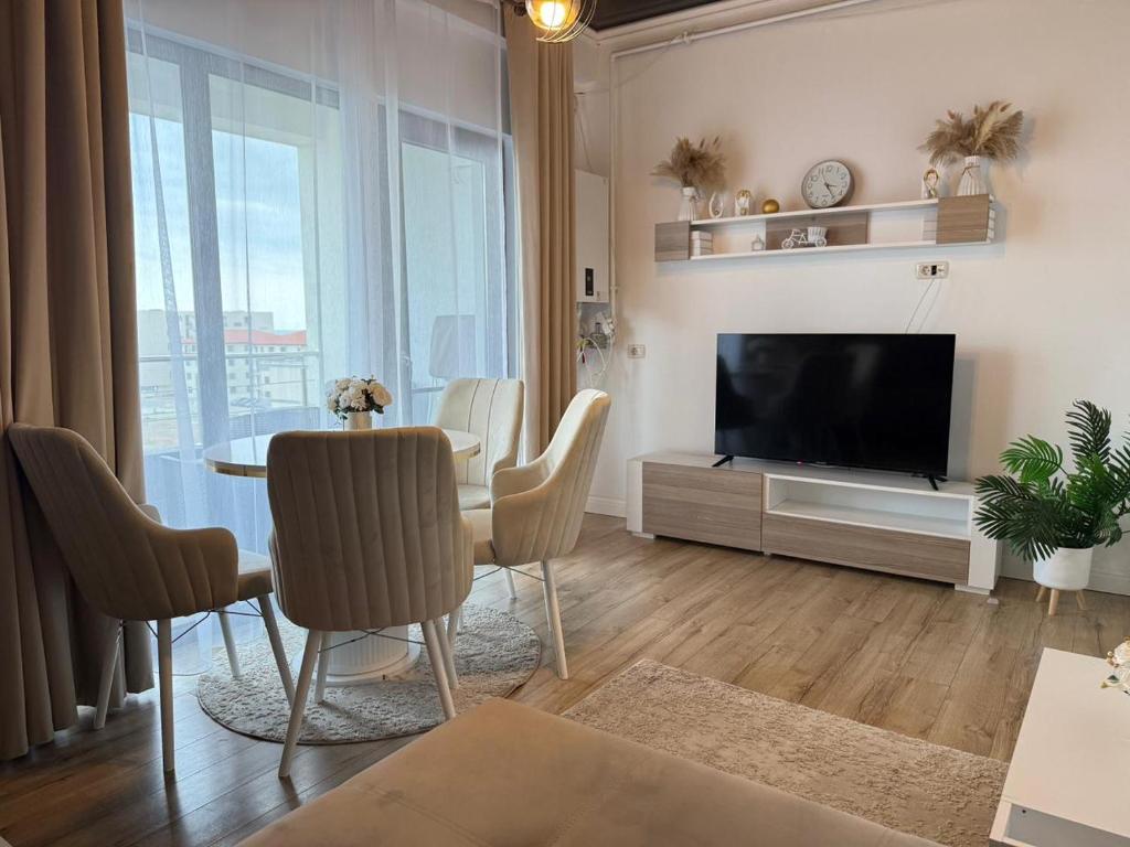 a living room with a table and a television at Cozy Crib 2 in Mamaia Sat/Năvodari