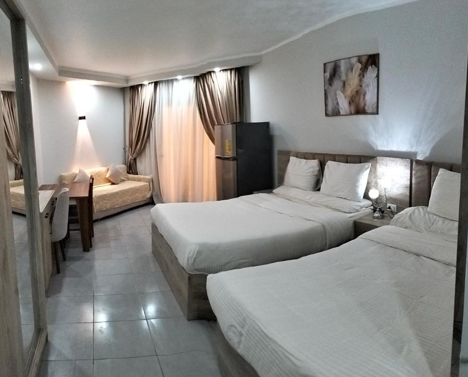 a hotel room with two beds and a desk at Scandic resort chalet in Hurghada