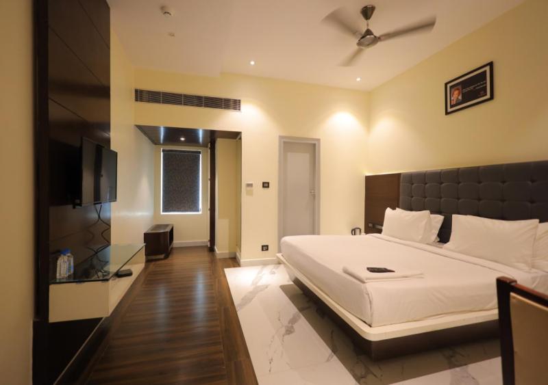 a bedroom with a bed and a flat screen tv at YAR INN CENTRAL in Vijayawāda