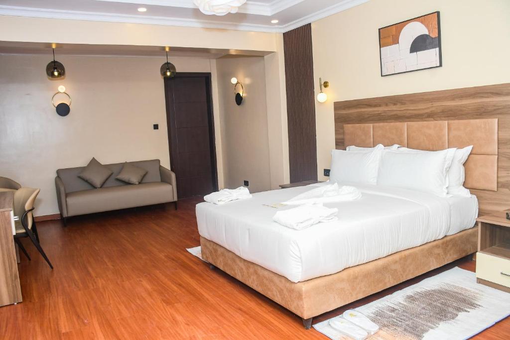 a bedroom with a large white bed and a couch at Sebai Luxury Suites in Naivasha