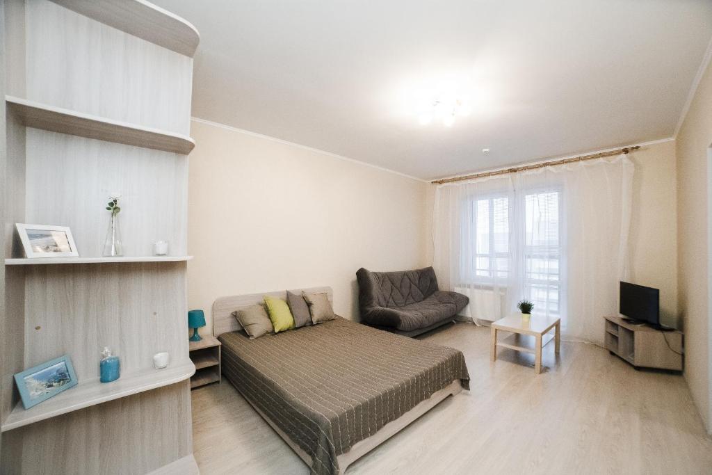 1 dormitorio con cama, sofá y TV en Apartment on Khakima with Kremlin View, en Kazán