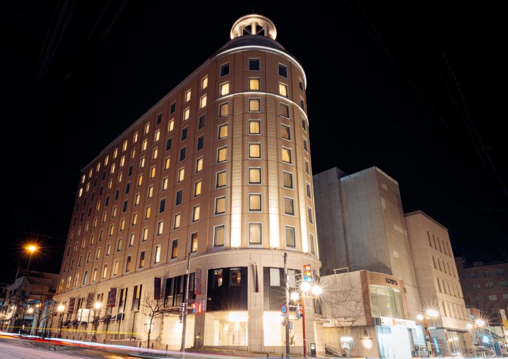 ein großes Gebäude mit einer Kuppel auf dem Dach bei Nacht in der Unterkunft Authent Hotel Otaru in Otaru