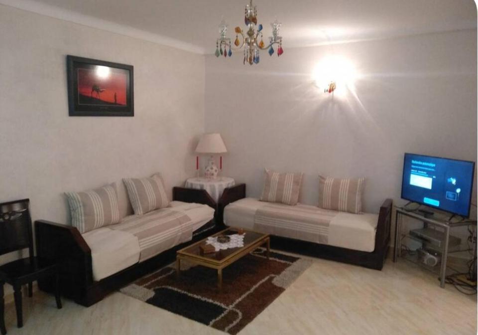 a living room with two couches and a tv at Apartment Centre Hamria in Meknès