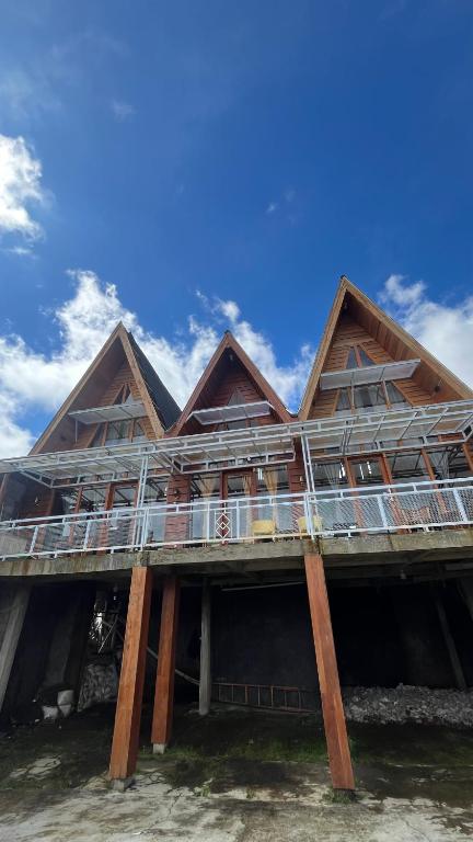 a wooden house on the beach with a blue sky at Cabin Dieng Db in Diyeng