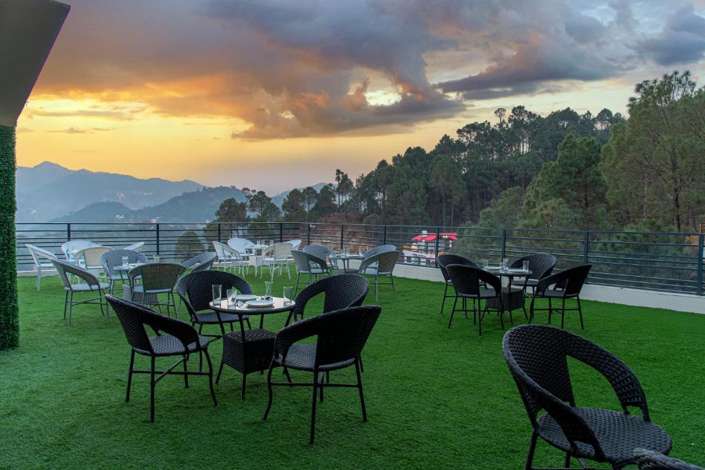 a group of tables and chairs sitting on the grass at Maverick Heights in Kasauli