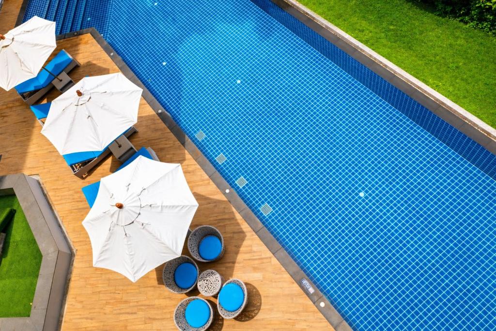 an overhead view of a swimming pool with umbrellas at Kata Beach Pool View Condo - 400m from the Beach in Kata Beach