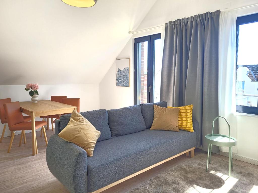 a living room with a blue couch and a table at Heiligenhafenbude 2 in Heiligenhafen
