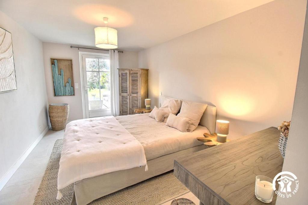 a bedroom with a large bed and a window at Le clos du figuier in Arzon