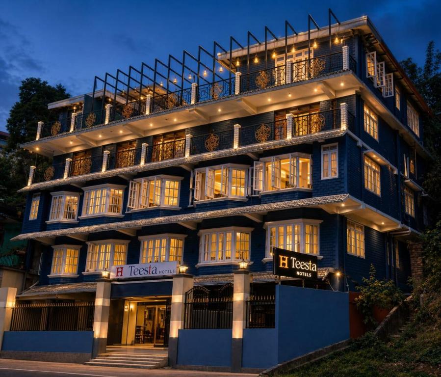a large blue building with lights on at Teesta Hotels, Kalimpong in Kalimpong
