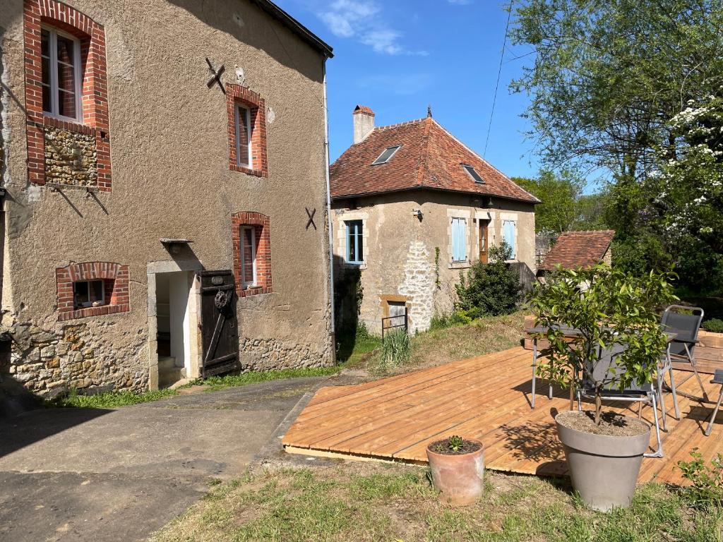 an old building with a wooden deck in front of it at Moulin de Saint-Civran in Saint-Civran