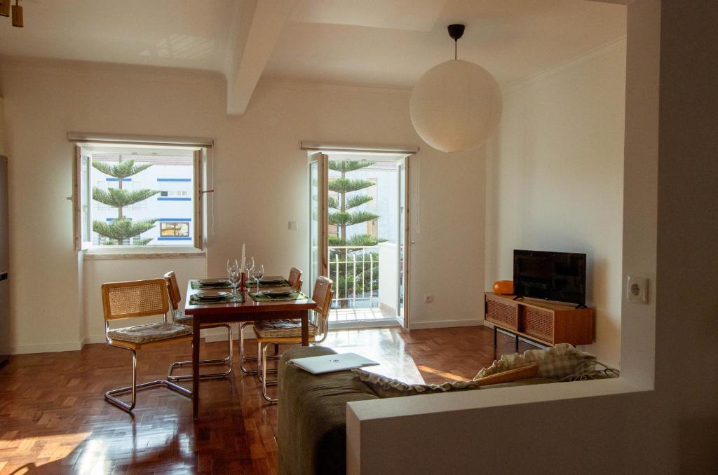 a living room with a table and a couch at Casa do Largo Ericeira in Ericeira