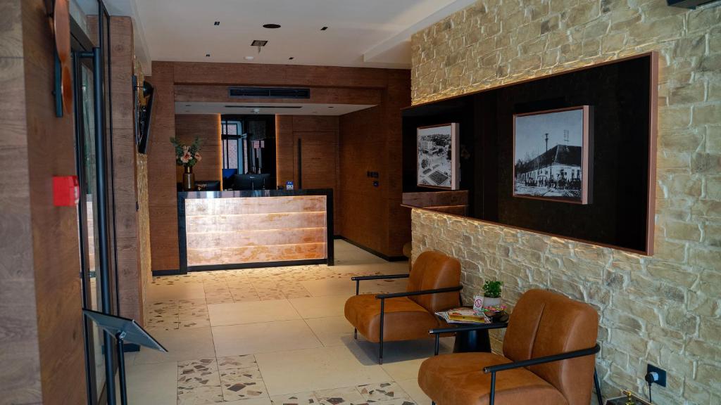 a lobby with chairs and a counter in a building at Hotel Central in Inđija