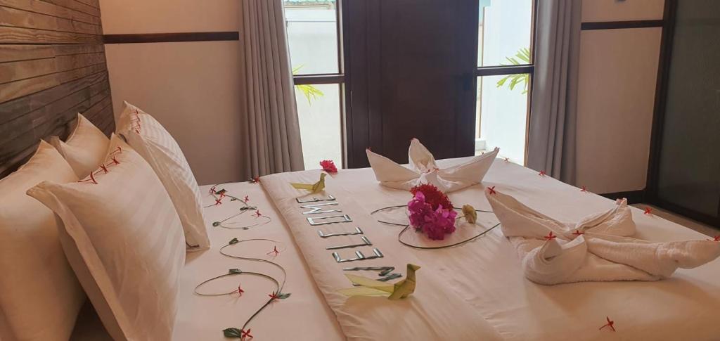 a white table with flowers on top of it at Luk inn at huraa in Huraa