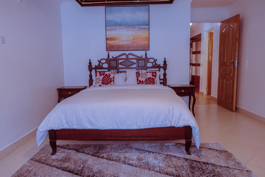 a bedroom with a large bed with red pillows at Greenpark Staycations in Athi River