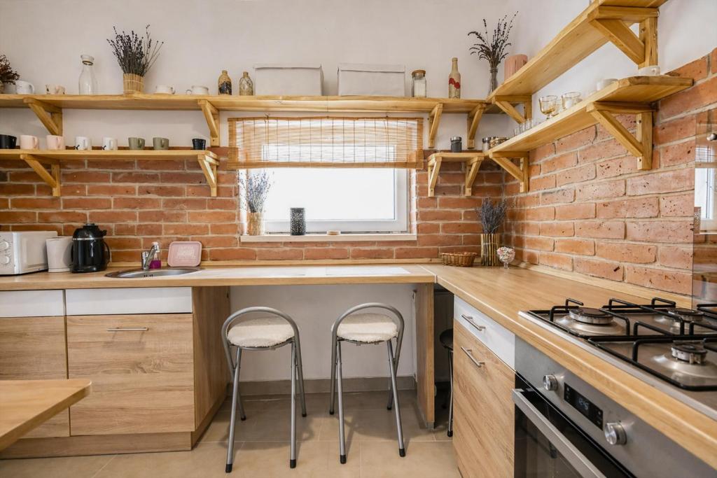 a kitchen with a counter and two stools in it at Héthajnal Apartman in Debrecen