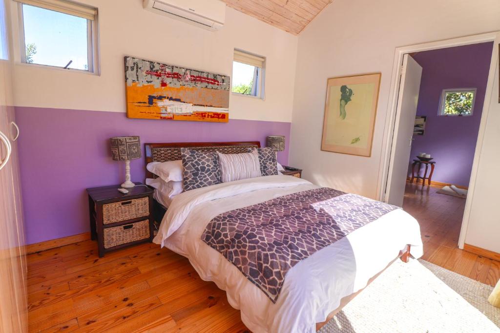 a bedroom with purple and white walls and a bed at Airconditioned Apartment for 3 guests. in Hermanus