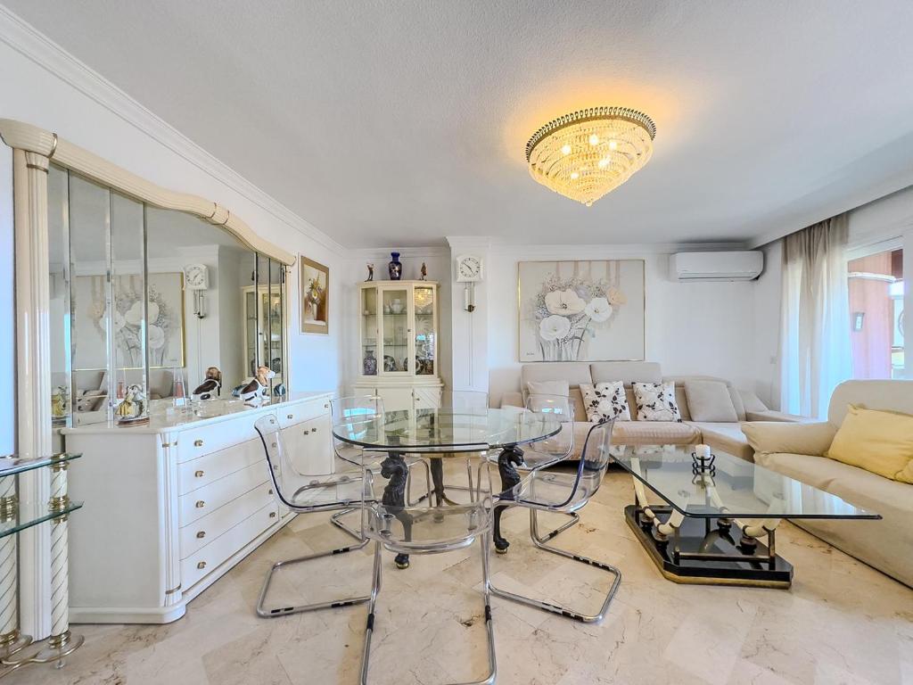 a living room with a table and a couch at Parque Marbella Three Bedroom Apartment in Marbella