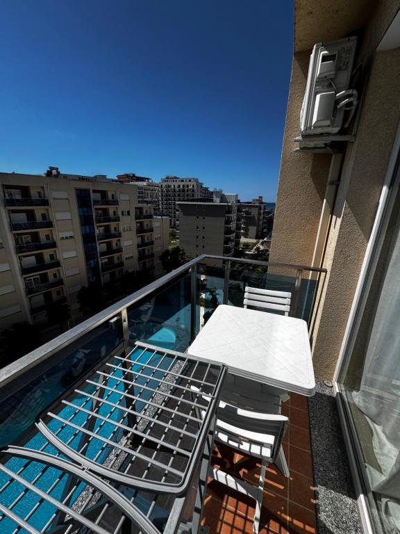 a balcony with a table and chairs on a building at Inis apartamans -50 m from beach in Shëngjin