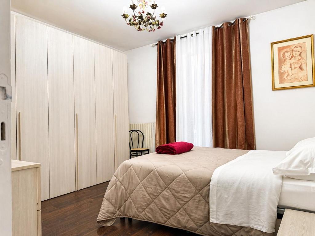 a bedroom with a bed with a red pillow on it at I Due Gelsi appartamento Green in Monte San Giusto
