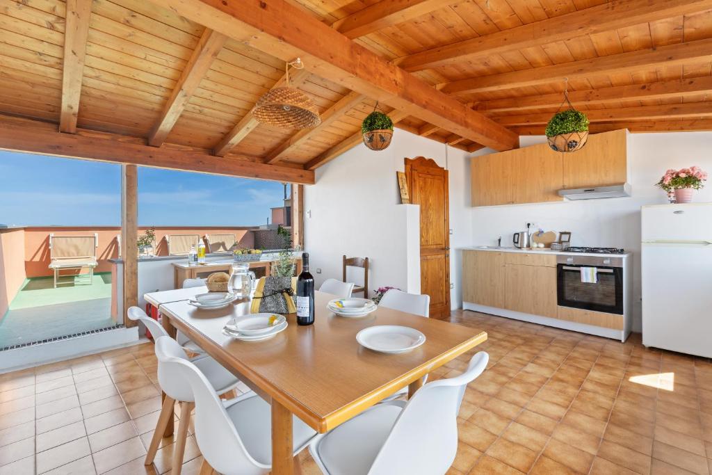 a kitchen and dining room with a table and chairs at Meravigliosa Terrazza Vista Mare in Tresnuraghes