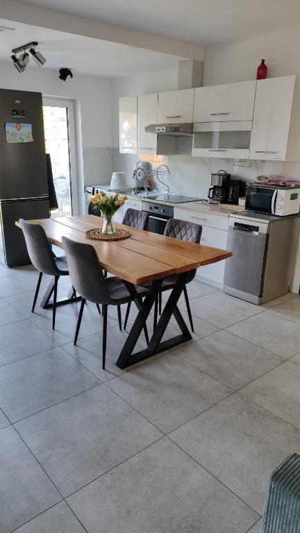 a kitchen with a wooden table and some chairs at The Country Stop Apartment in Łęki