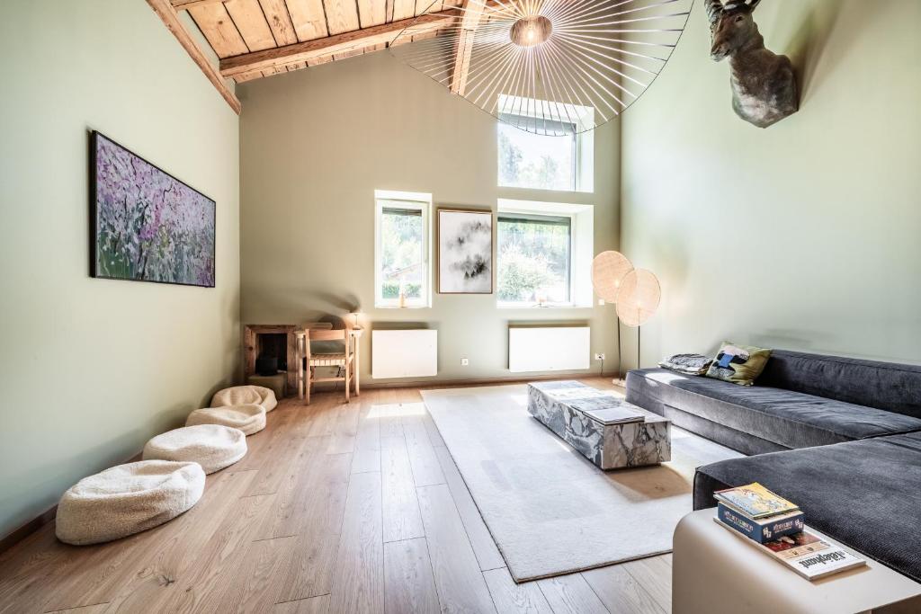 a living room with a couch and a table at Chalet Design Terre De Sapins in Mont-Saxonnex
