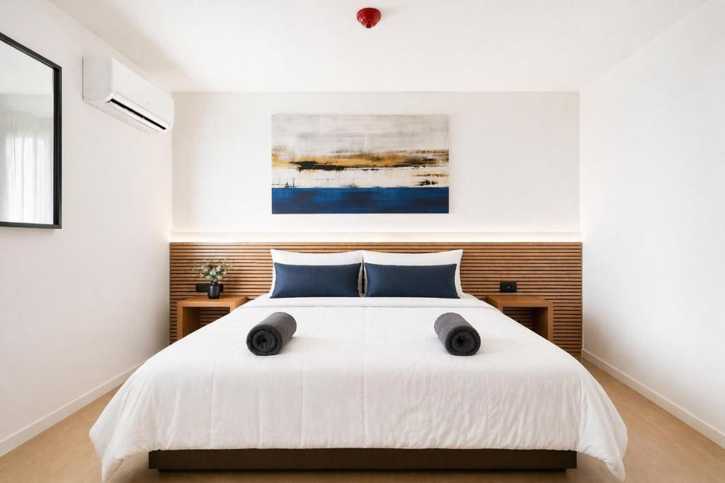a bedroom with a white bed with blue pillows at Nova MSuites Valencia in Valencia