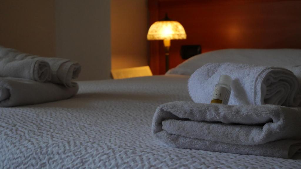 a pile of towels sitting on top of a bed at Hotel Casa Vacanze Orchidea in Pinerolo
