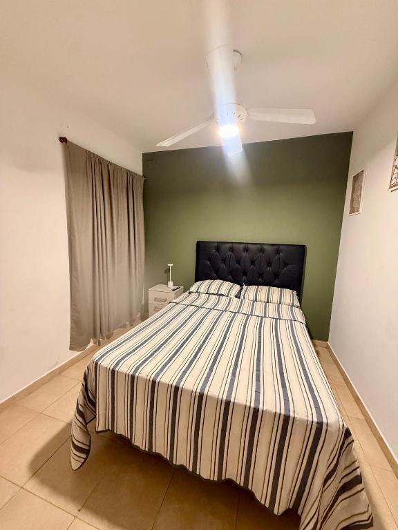 a large bed in a room with a green wall at Estadía Ideal para 2 personas in Resistencia
