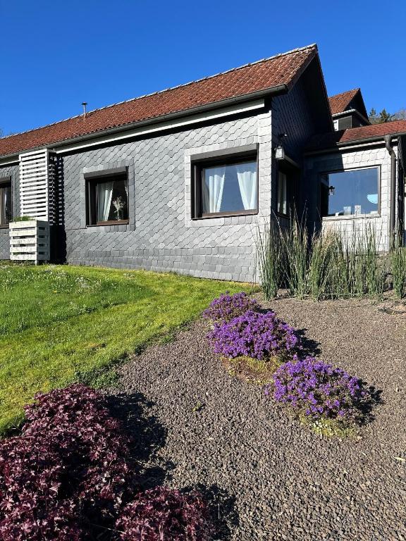 a house with purple flowers in front of it at Ferienhäuschen Gartenblick in Friedrichroda