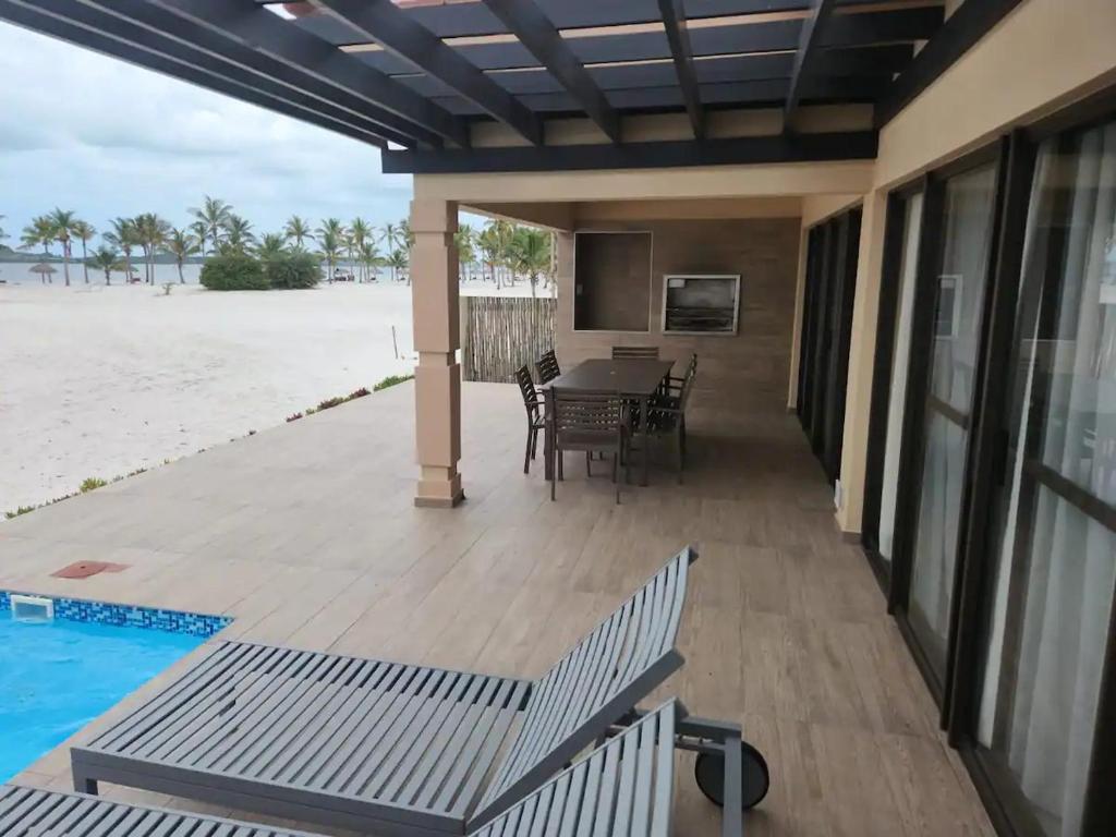 a patio with a table and chairs next to the ocean at Serena in Gueima