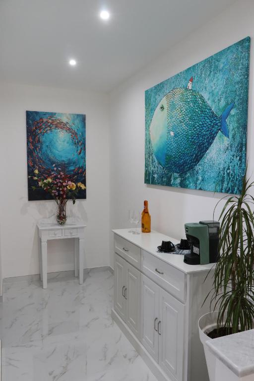 a kitchen with a fish painting on the wall at BlueBay room Calabria in Vibo Valentia Marina