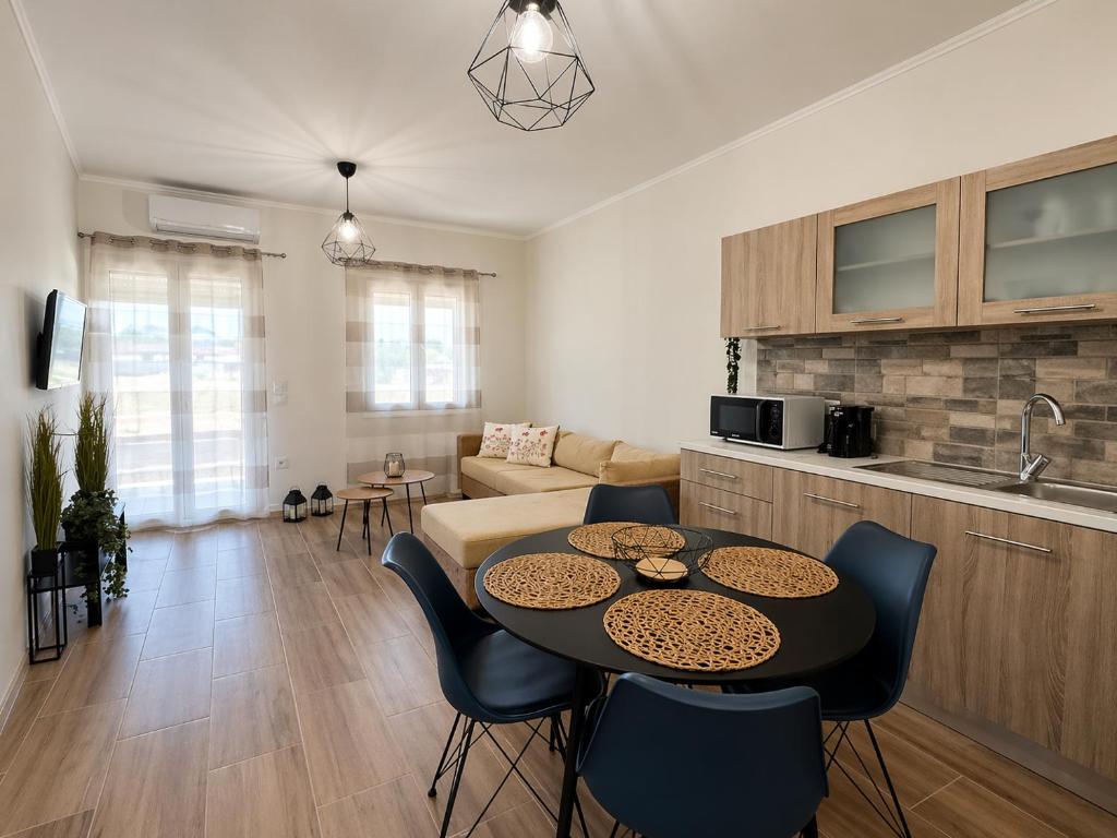 a kitchen and a living room with a table and chairs at Casa Plati 1 - Modern Escape with Pool & Garden in Platí