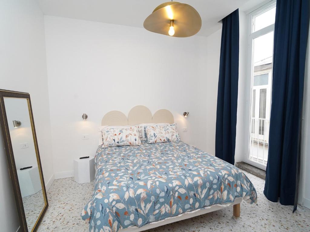 a bedroom with a bed with blue curtains and a mirror at Incoming Medina in Naples