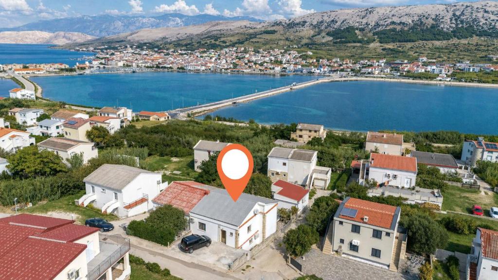 a town with a red arrow on top of a house at Apartments Zeljko in Pag