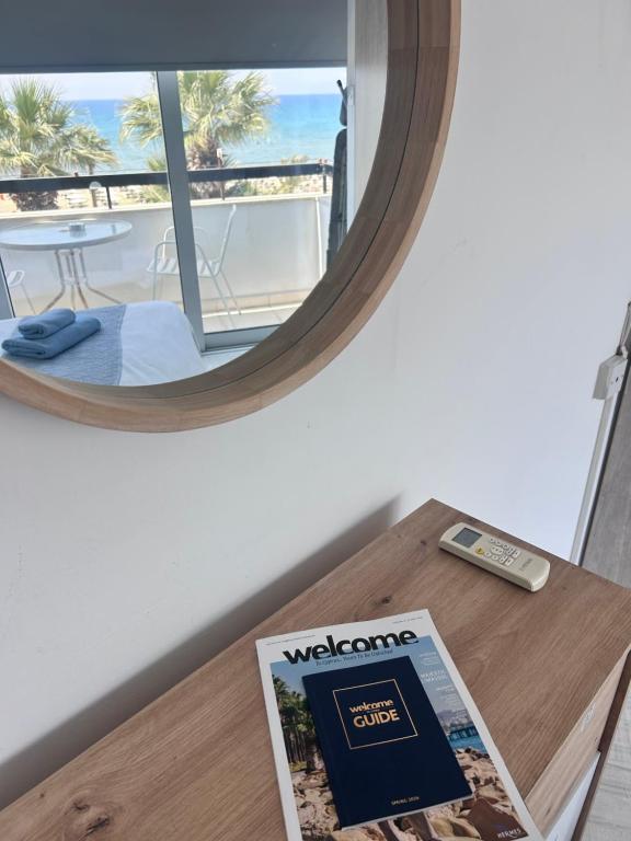 a magazine sitting on a table with a mirror at Alex Beach Apartment 203 in Larnaca