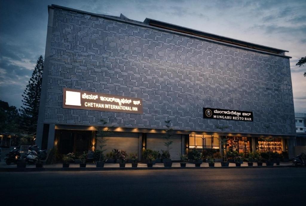 a blue brick building with a sign on it at Chethan International in Bangalore