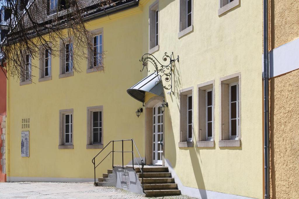 a yellow building with stairs in front of it at Hotel Fontana Selb in Selb