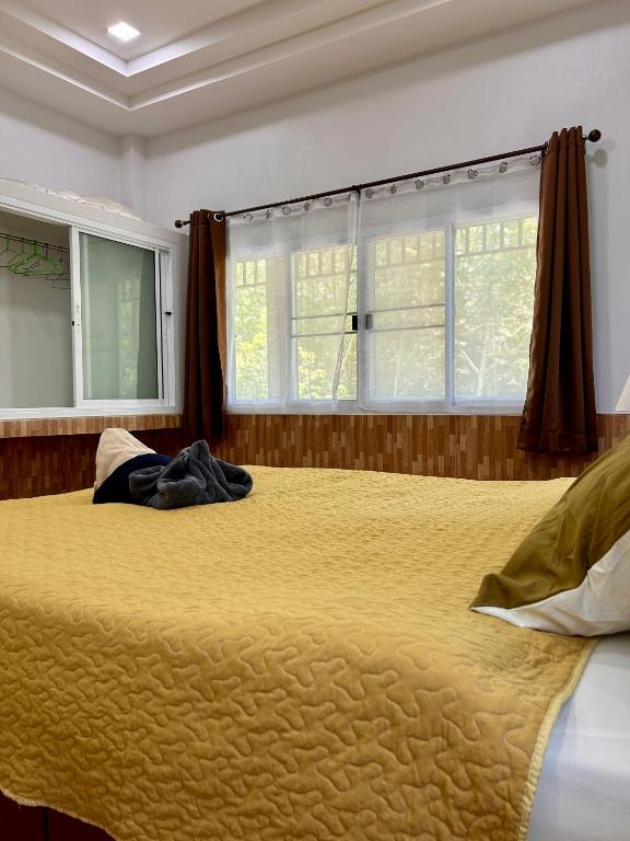 a bedroom with a large yellow bed with a window at Spacious 1br White House in Ban Nok