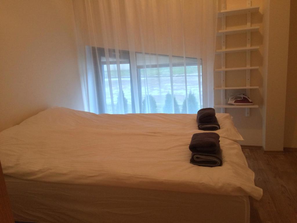 a bed with two towels on it with a window at Fortuuna 5 Apartment in Tartu