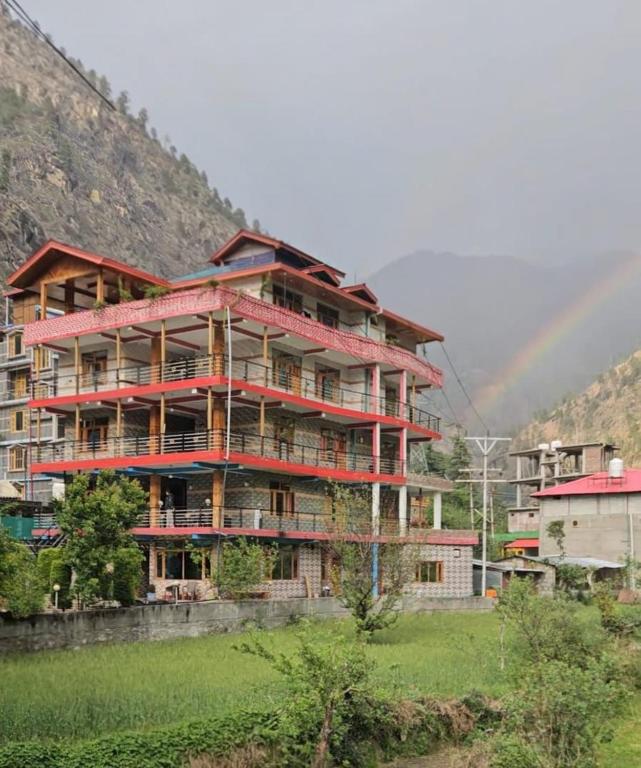 a large apartment building with a rainbow in the background at House of Brahma Kasol in Kasol