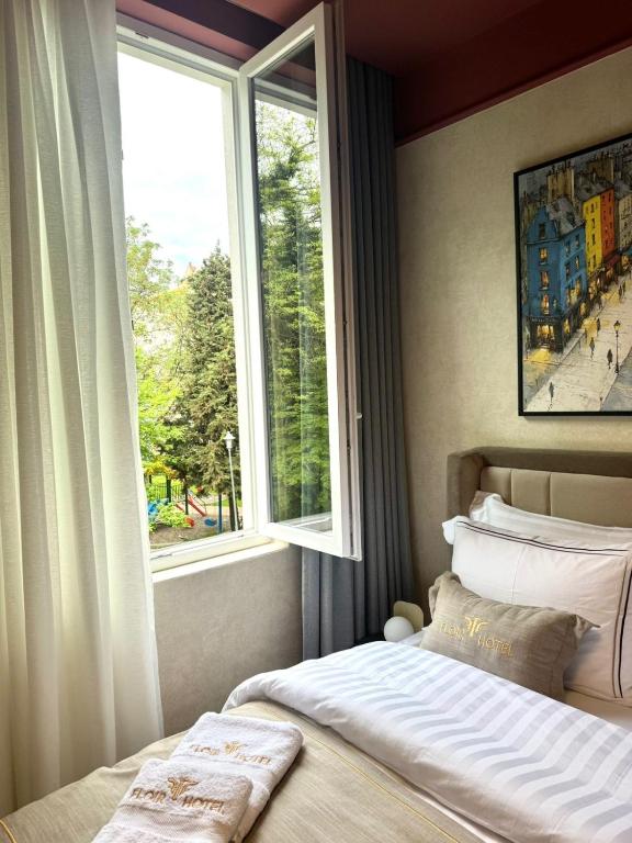 a bedroom with a large window and a bed at Shkoder City Center - Floir Hotel in Shkodër