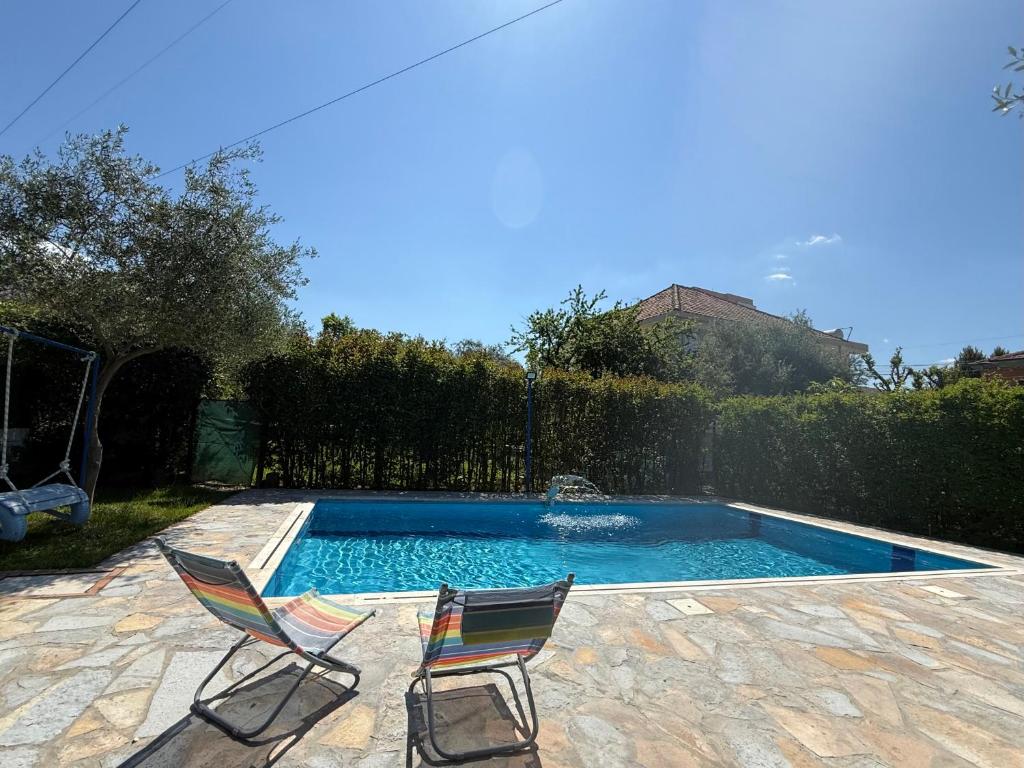 two chairs sitting next to a swimming pool at The Bs Stay in Tirana