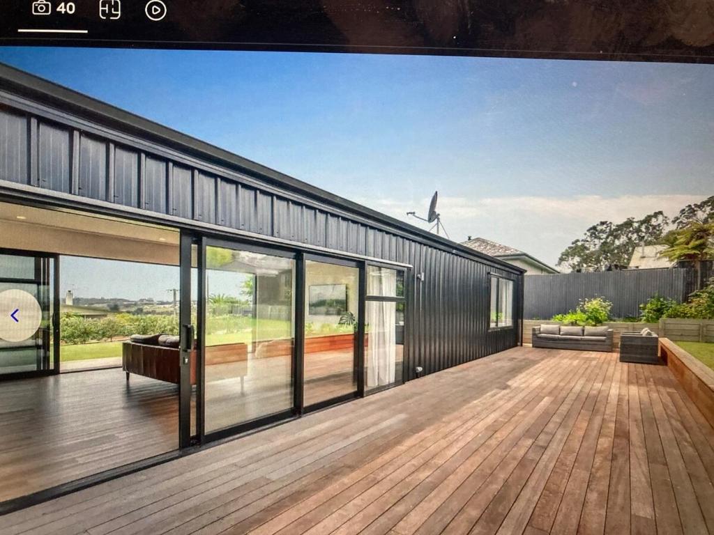 an external view of a house with a wooden deck at The Batch in Oamaru