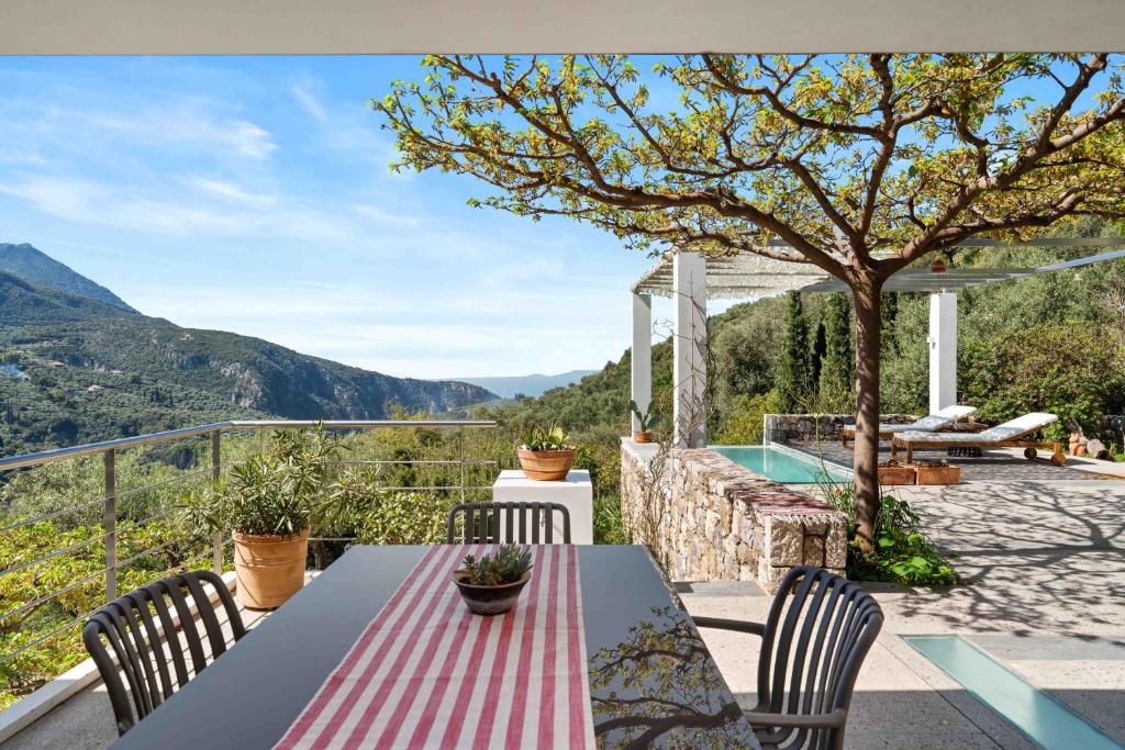 a table and chairs on a patio with a view at Mediterra Messinia in Kalamata